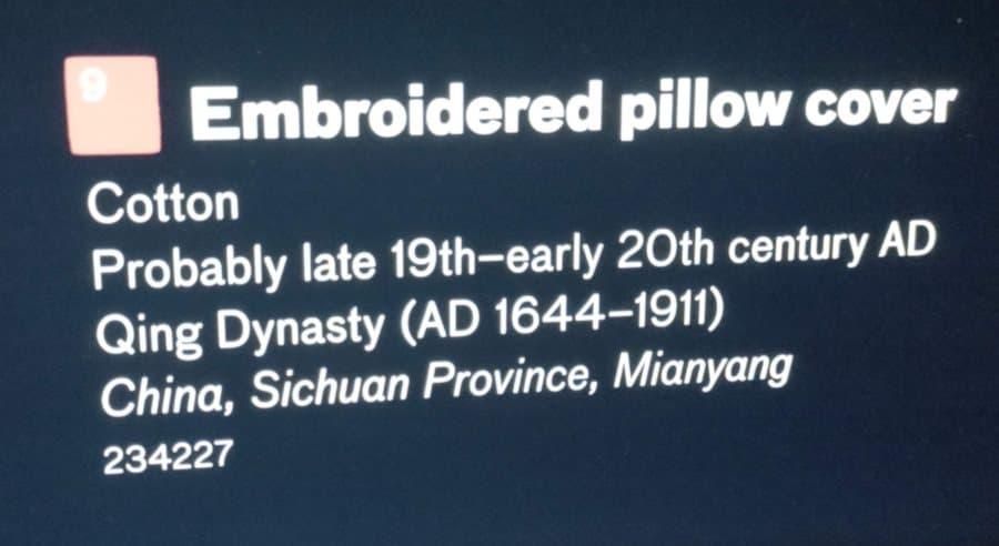 Display placard for Embroidered Pillow Cover that reads:
Cotton
Probably late 19th-early 20th century AD
Qing Dynasty (AD 1644-1911)
China, Sichuan Province, Mianyang
234227