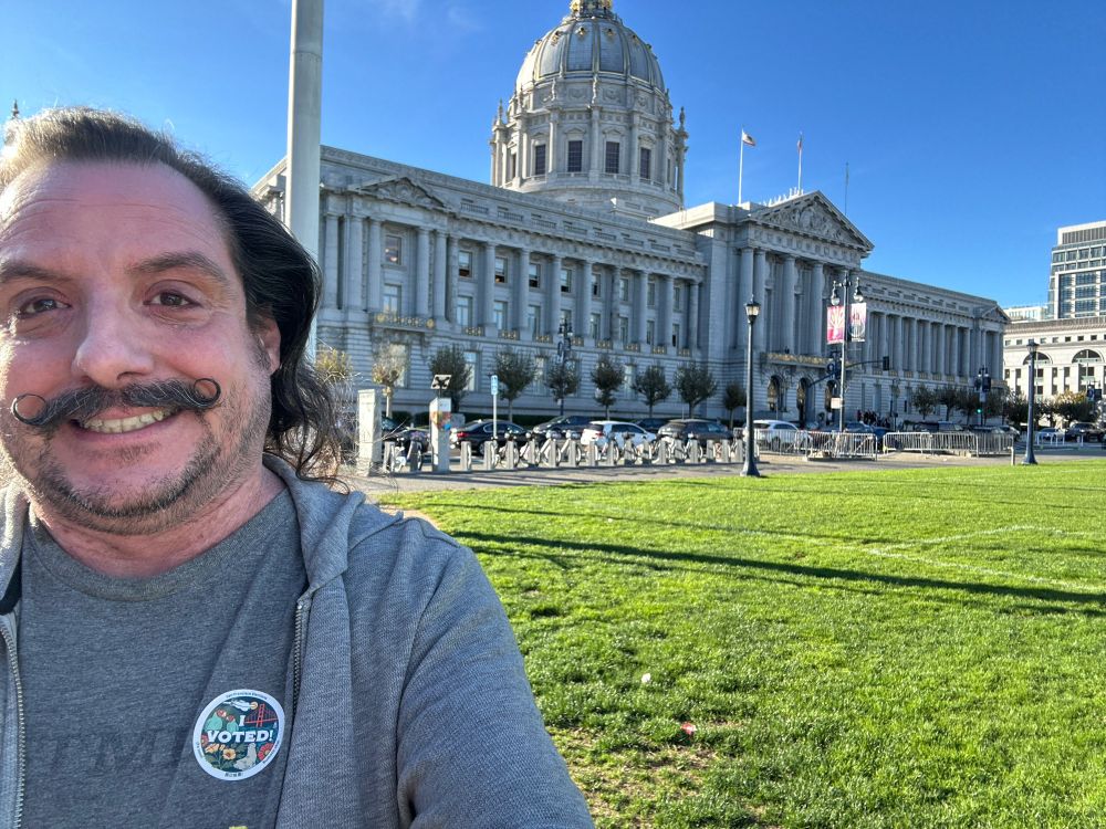 Me in front of San Francisco city hall grinning ridiculously and showing off my “I Voted!” sticker