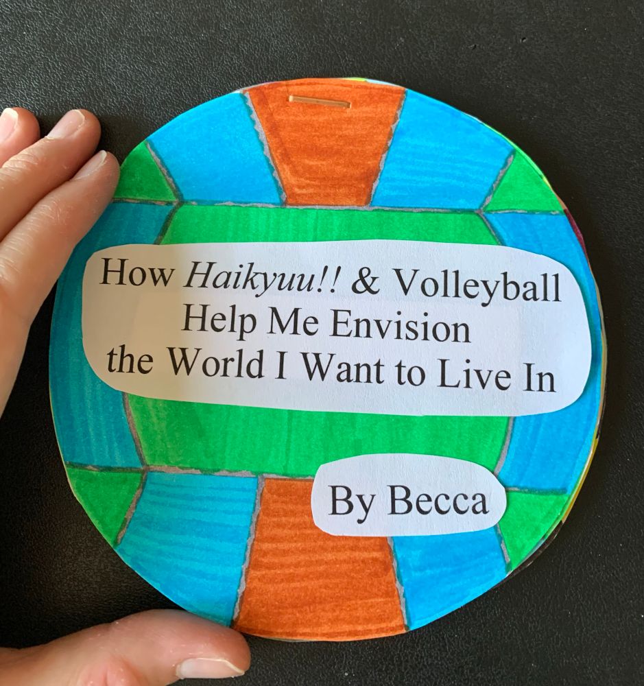 A small zine where the pages are circles decorated like volleyballs. the first page is a volleyball with earth colors. The zine text is typed, cut out, and taped on the volleyball. it says "How Haikyuu!! and Volleyball Help Me Envision the World I Want to Live In.