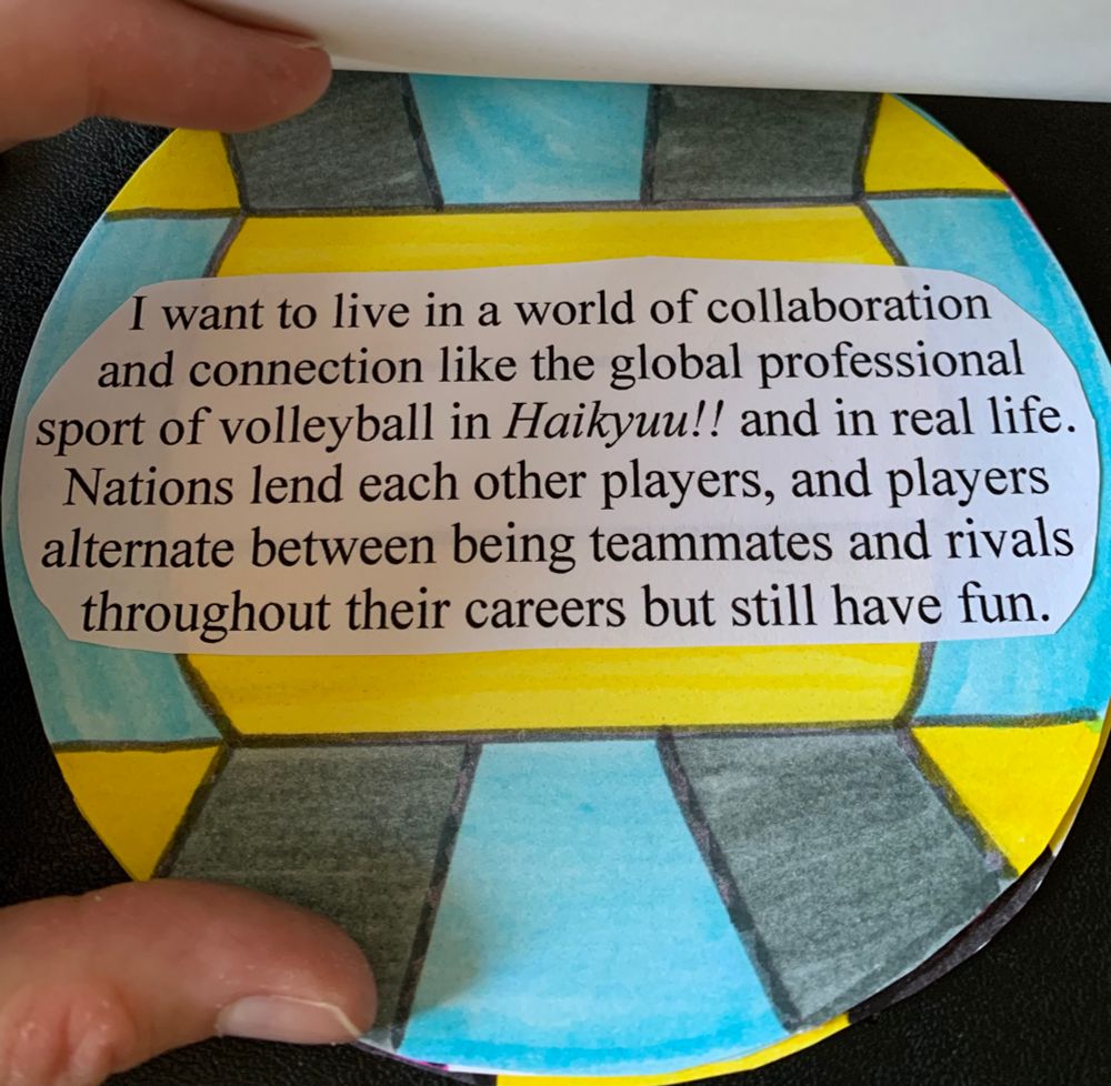 A page with a volleyball that has blue, gray, and yellow colors. The text says "I want to live in a world of collaboration and connection like the global profession sport of volleyball in Haikyuu!! and in real life. Nations lend each other players, and players alternate between being teammates and rivals throughout their careers but still have fun.