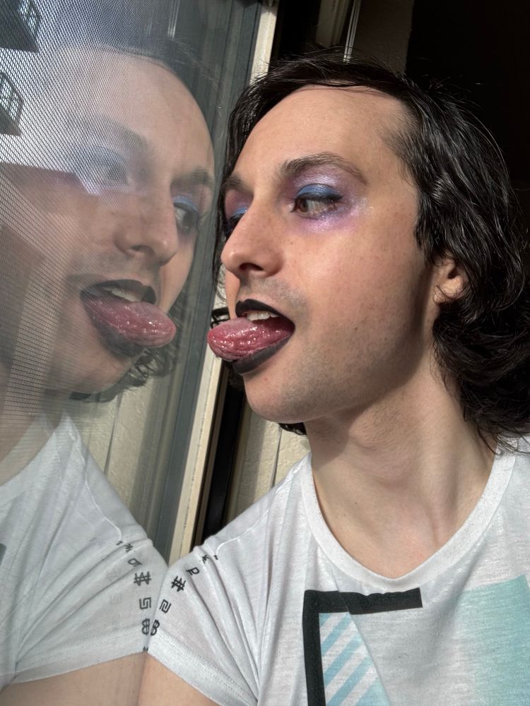 Harley touching tongues with her reflection in a window