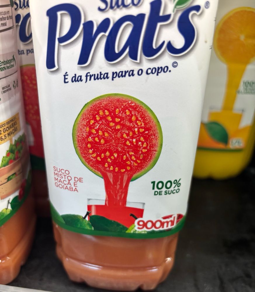 Suco misto de goiaba e maçã prat's. A ilustração da goiaba está no meio em destaque, a da maçã está escondida atrás do conteúdo líquido declarado de 900ml.