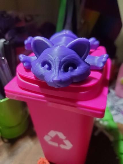 a purple 3D printed raccoon fidget on top of a mini recycle trashcan