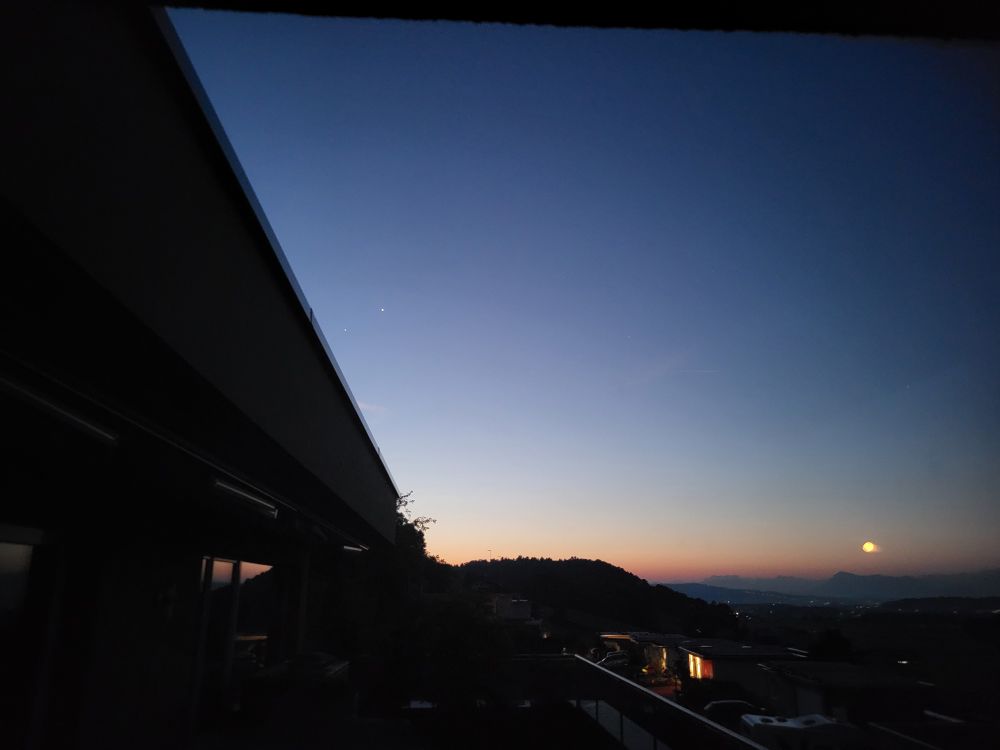 Der Morgenhimmel mit Venus und Jupiter. Im Fenster, durch das fotografiert wurde, spiegelt sich der untergehende Vollmond. 