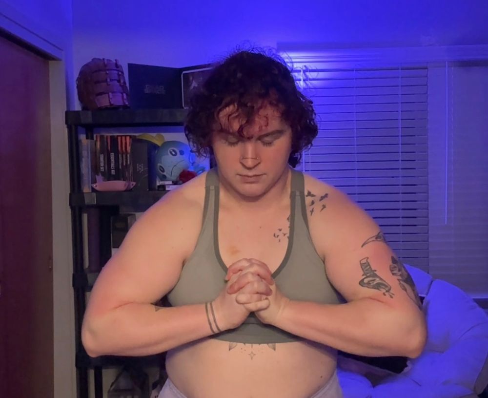 Fae flexes their arms and traps