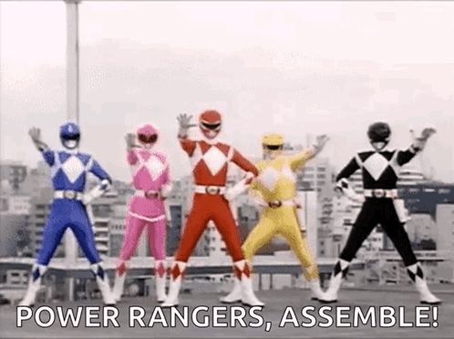 a group of power rangers are standing next to each other on a rooftop .