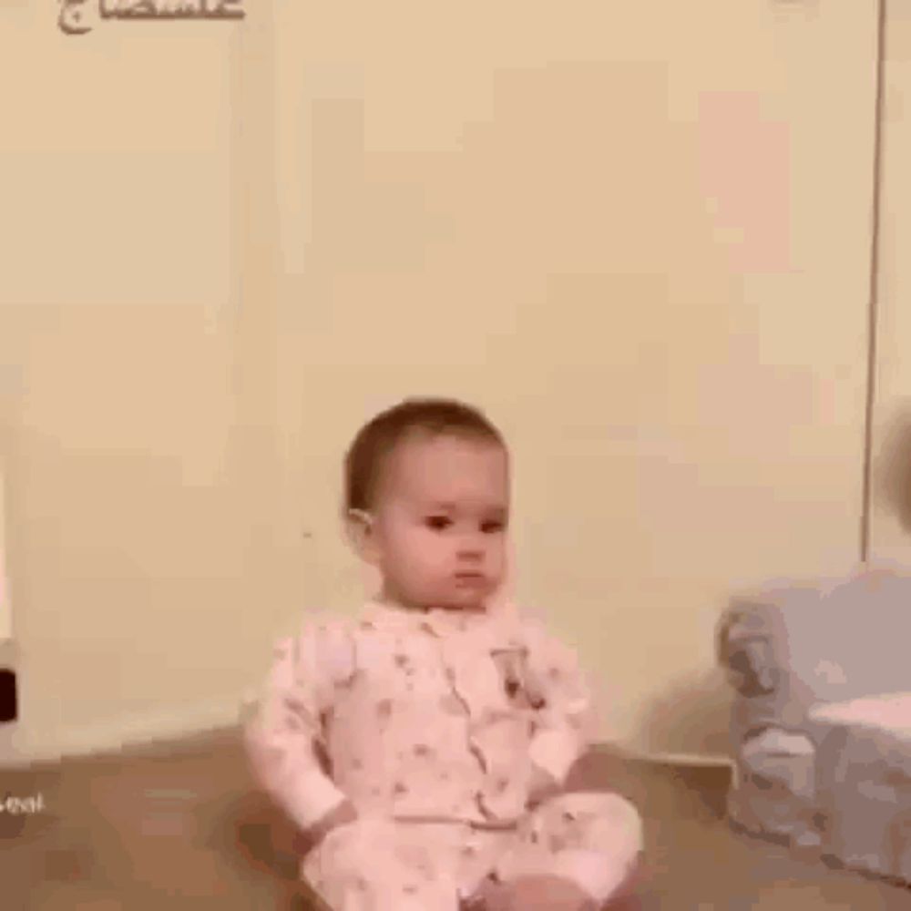 a baby is making a funny face while wearing a pink pajama set .