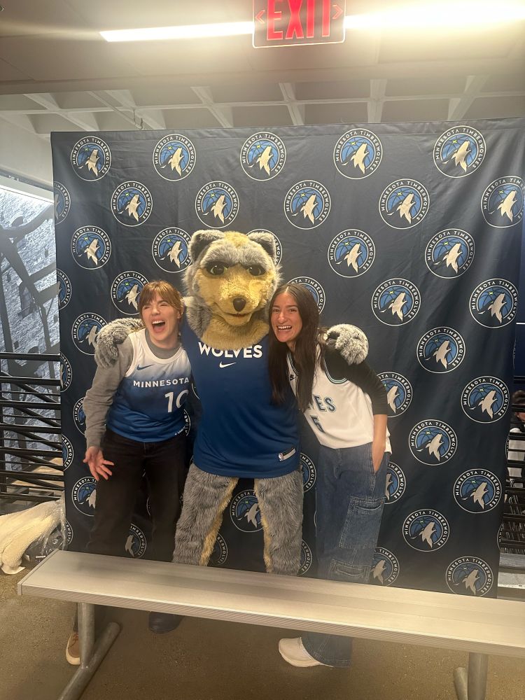 At Target Center for the Timberwolves Heat game. Two friends taking a pic with Crunch, the Wolves mascot. Big smiles