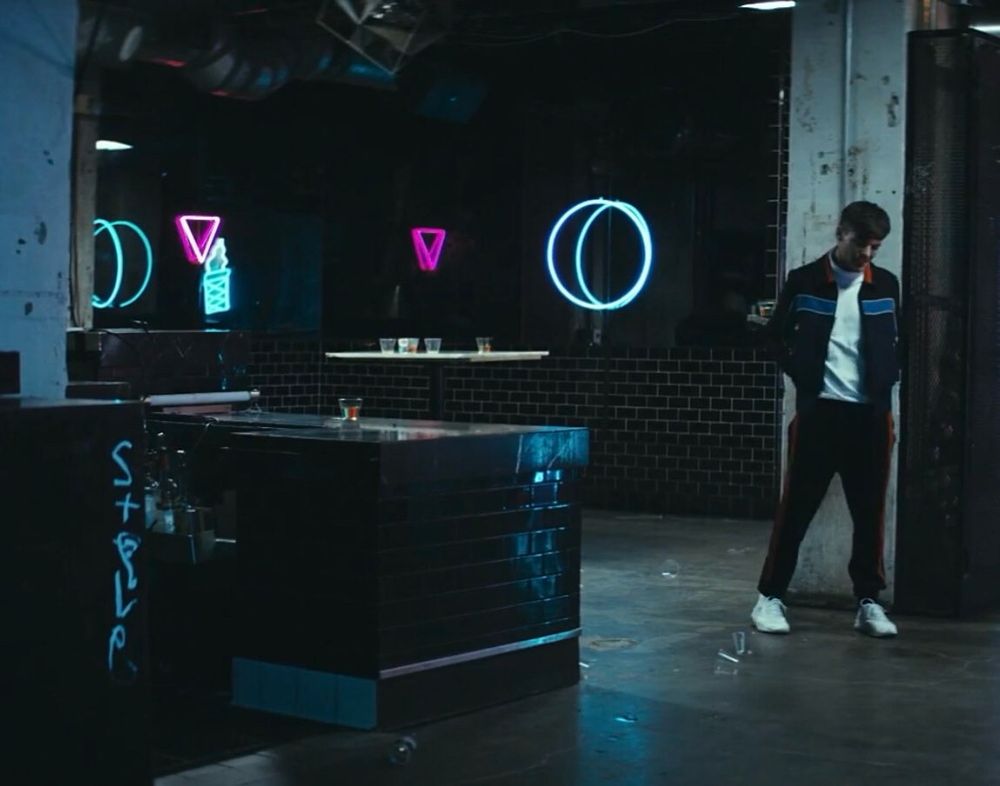 Louis Tomlinson in the bar in the Miss You music video with the pink triangle. On the wall says either Steve or Style, it’s one of those writings that is designed to be read both ways, in graffiti.
