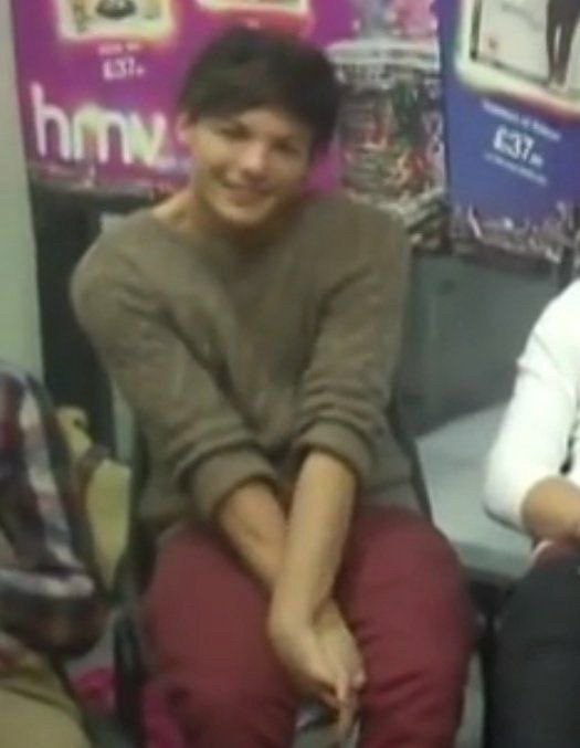 Louis curls his hands together to shrink space, sitting. It’s the sweater he wore on the “I like girls” interview in early 1D