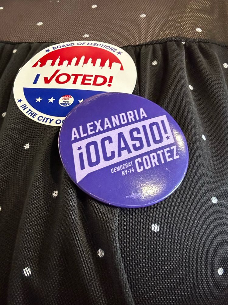 An “I voted” sticker and a pin supporting Alexandria Ocasio-Cortez