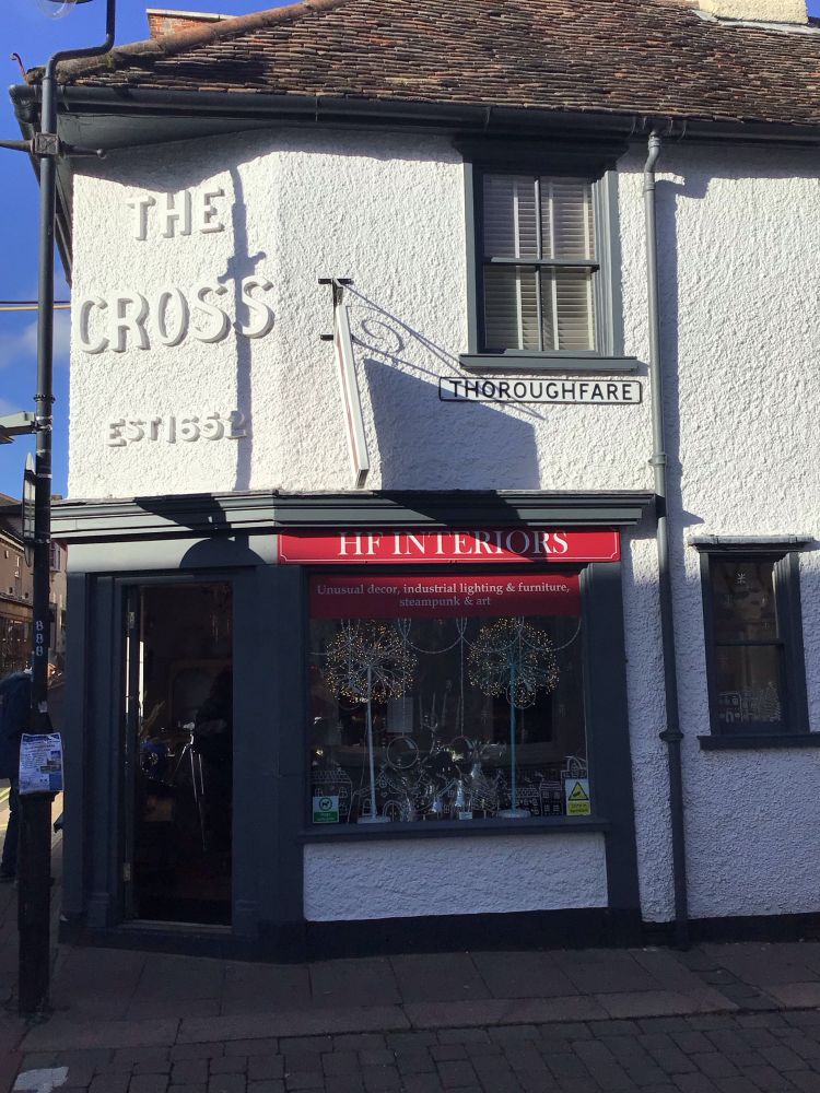 Colour image of The Cross founded in the 17th century and on the corner of a street named Thoroughfare.