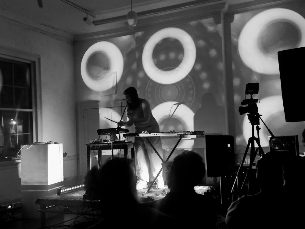 Black and white image of the artist Echo Juliet on stage.