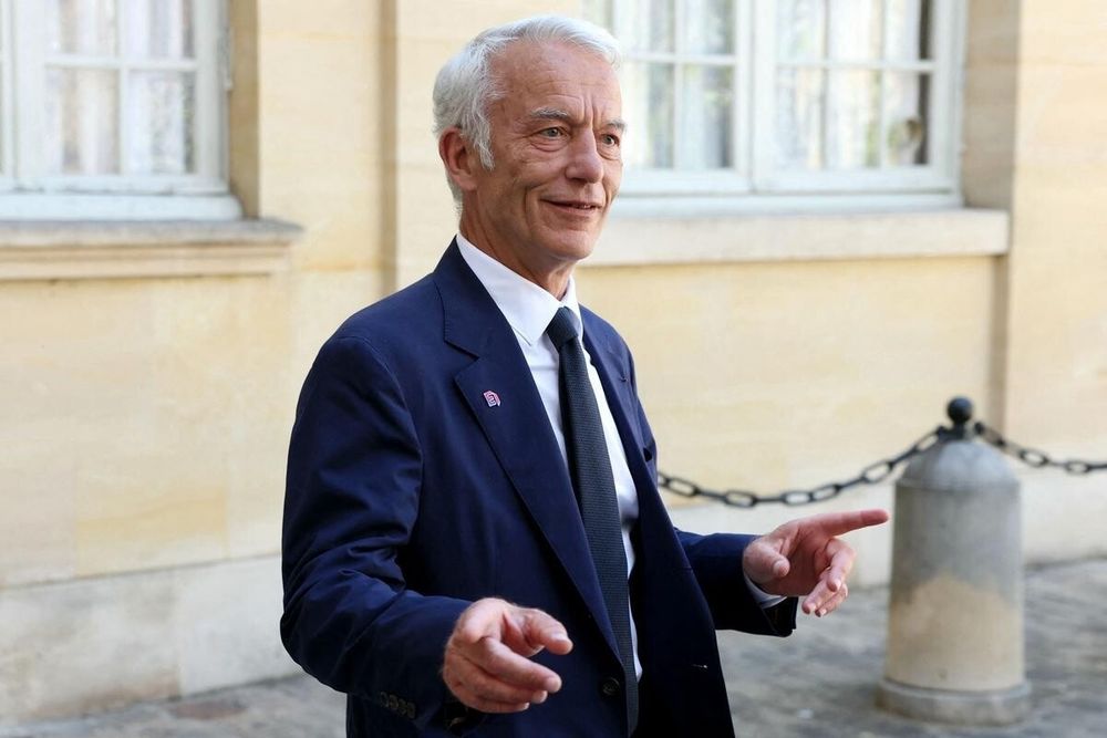 Un requin en costume qui écarte les mains.