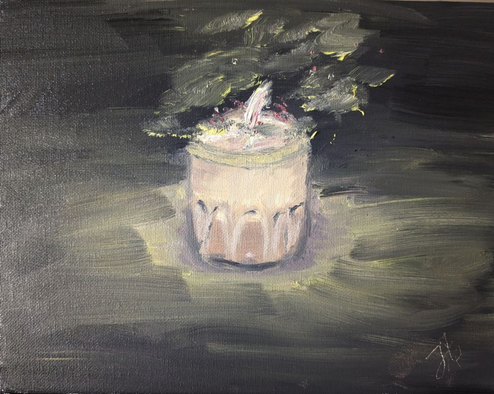An oil painting depicts a single candle in a glass holder, its flame softly glowing at the center of the composition. Loose, expressive brushstrokes in muted yellows, greens, and ochres suggest the flickering light and the gentle illumination of its surroundings. The background is dark, rendered in layered strokes of deep grey and black, contrasting with the candle’s pale, creamy tones. Hints of yellow and pink near the flame evoke the warmth and movement of candlelight. 