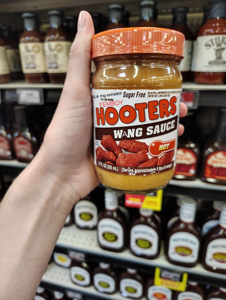 Can of Hooters Wing Sauce badly edited say "FEMBOY Hooters Want Sauce" there is also an edited claim of containing "0.4 mg estradiol"