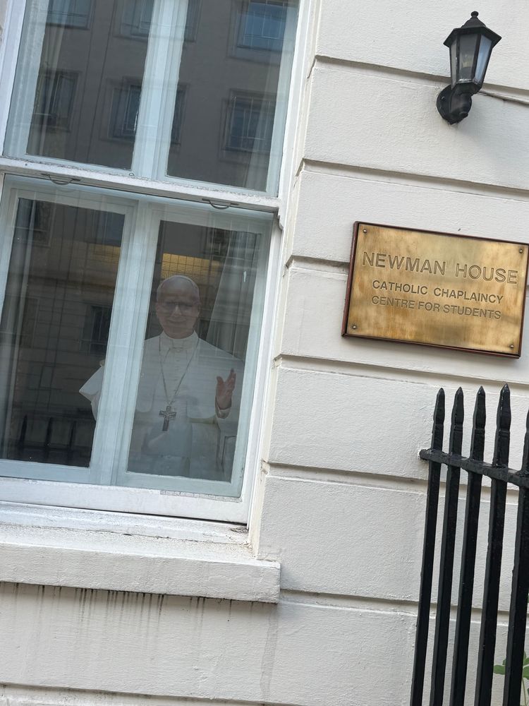 Cardboard cut-out of the Pope looking out of a window