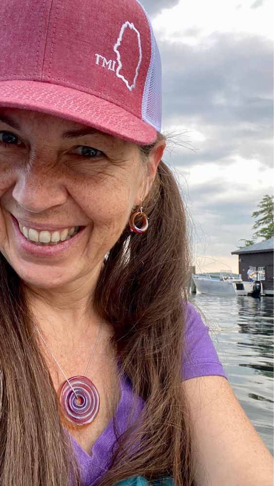 52-year-old woman in a red ball cap in a kayak on Lake Winnepesaukee, NH
