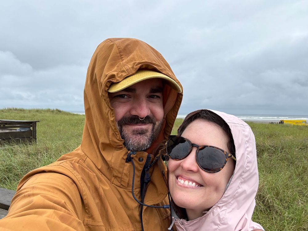 Me and my wife Elizabeth in rain coats on the grassy coast of Washington
