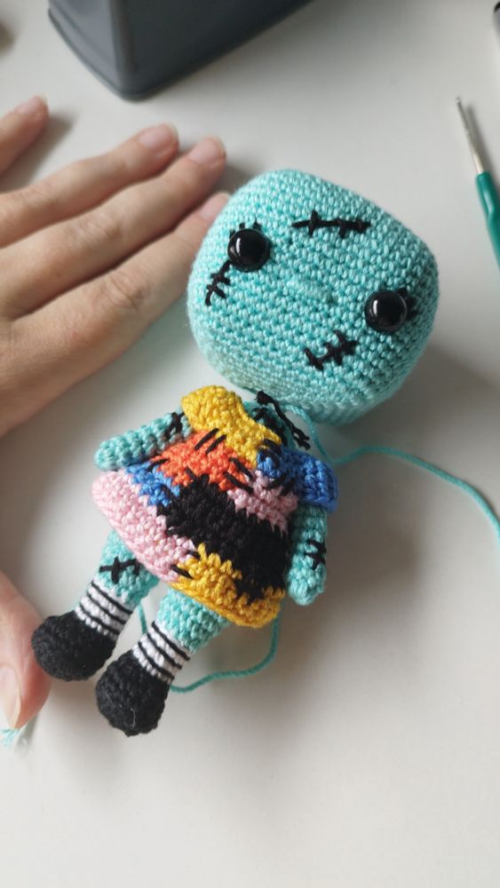 Amigurumi a medio tejer de Sally (Pesadillas antes de Navidad) sin pelo y con la cabeza estilo funko un poco separada del cuerpo.
En la esquina izquierda se ven los dedos de mi mano abierta en forma de "L" para tener una referencia del tamaño que va tener del amigurumi finalmente (unos 13cms)