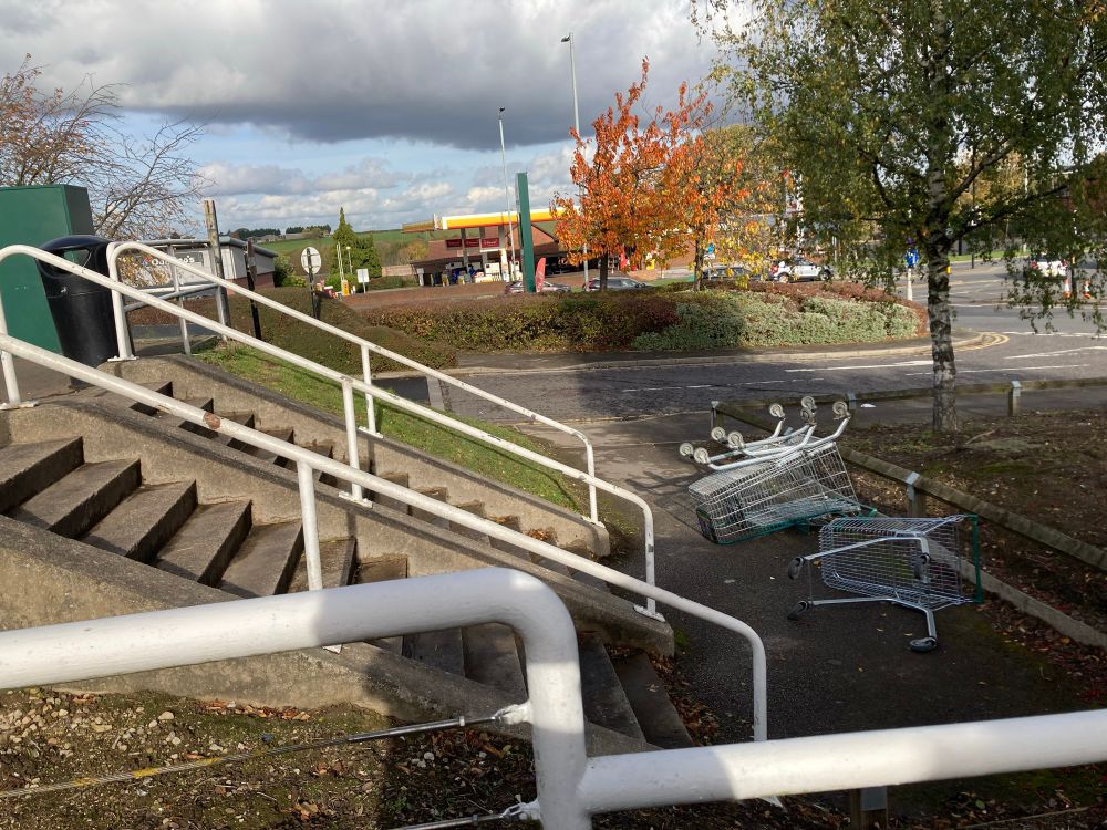 Three upside down shopping trolleys at the bottom of some stairs