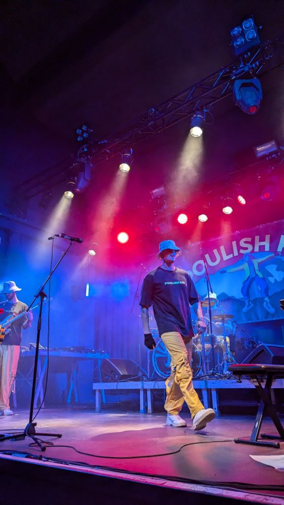 POULISH KID on stage with colorful lights and an energetic attitude is running across the stage.