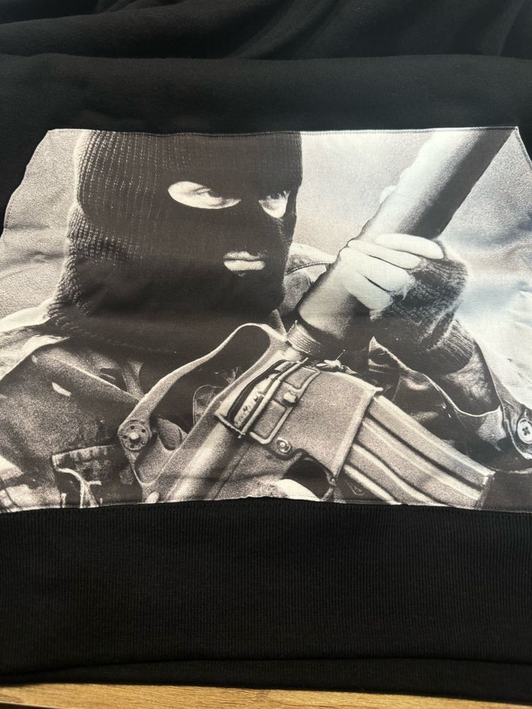 Hoodie kangaroo pouch printed with image of provisional fighter wearing a balaclava and holding an armalite rifle. 