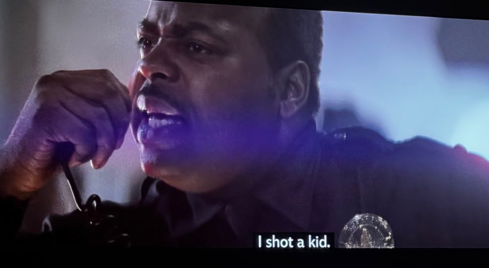 Still from Die Hard movie. Cop speaking into CB. SUBTITLE reads, I shot a kid. 
