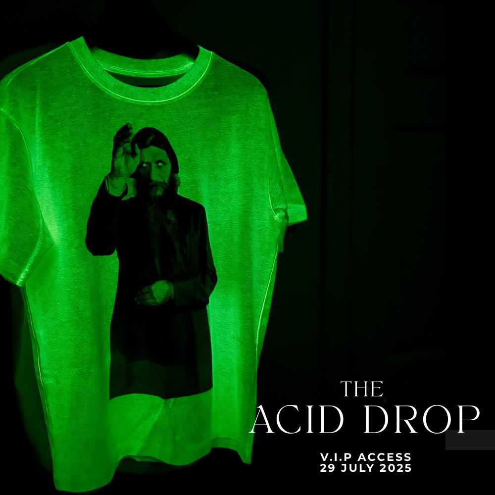 Glow in the dark tshirt with depiction of Rasputin raising his right hand. Shirt is glowing bright green in darkness. Text in white, bottom right of image reads The Acid Drop VIP access 29 July 2025