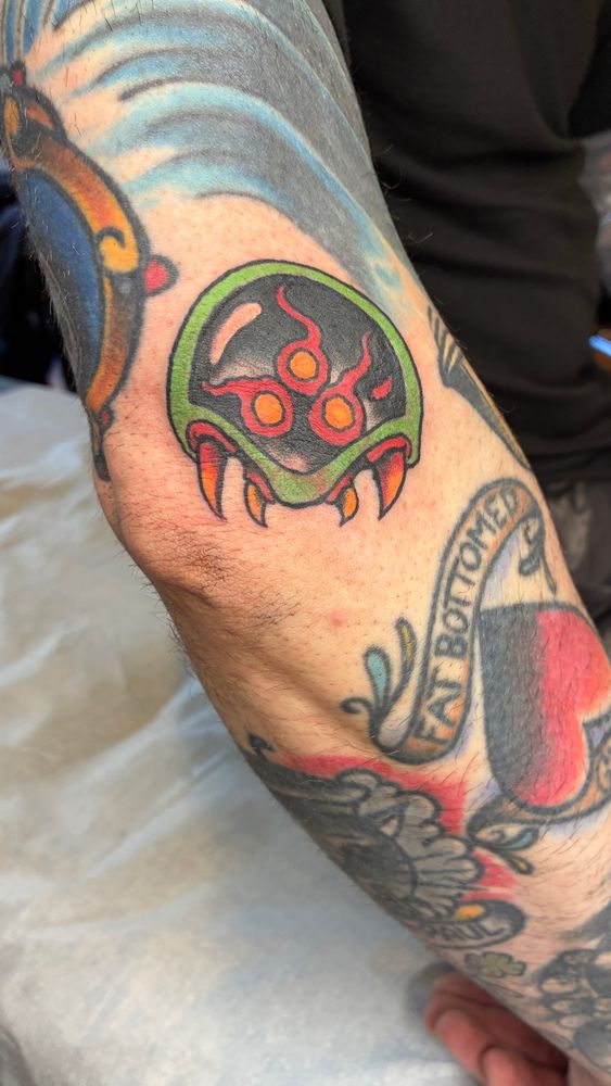 Close up of a Metroid tattoo on an arm 