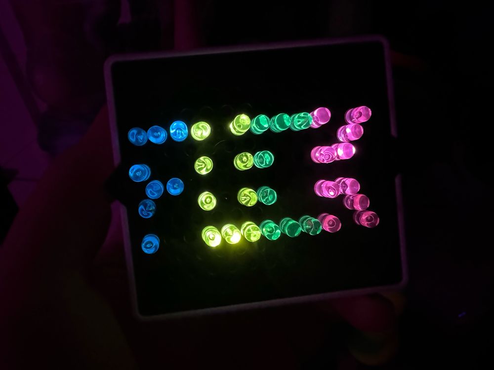 A small little brite that says fuck in blue, yellow, green, and pink 