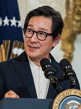 A picture of Ke Huy Quan at the dais of the president of the United States