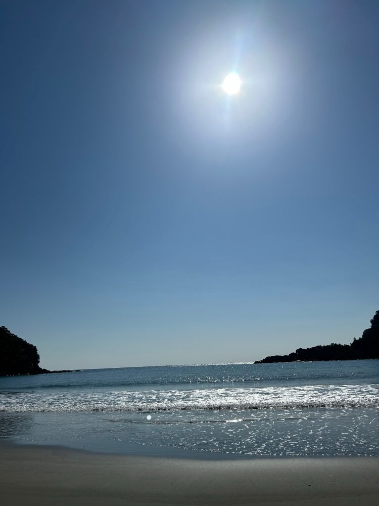 海辺(砂浜)の写真。
画像の3分の2くらいが空。
太陽が上のほうにある。