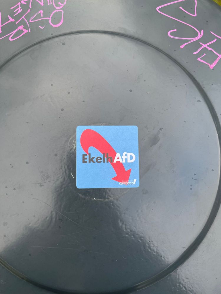 Bild eines geschlossenen Mülltonnendeckels von oben. Richtigerweise klebt ein #campact Aufkleber mit dem Schriftzug EkelhAfD drauf