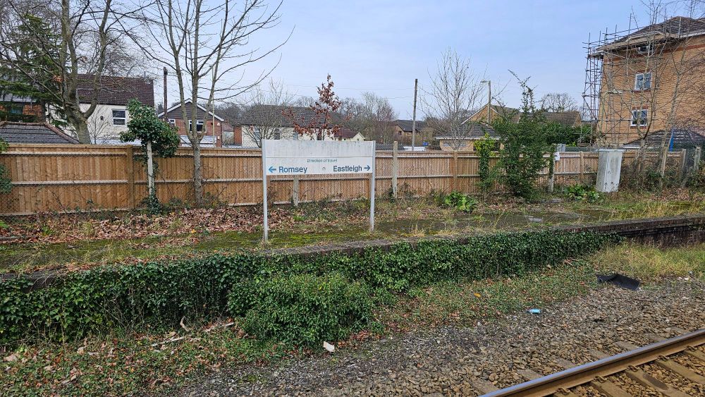 An old sign on the disused platform showing the direction of travel for trains. Although all trains go to Romsey. One direct, the other via Eastleigh and Southampton Central