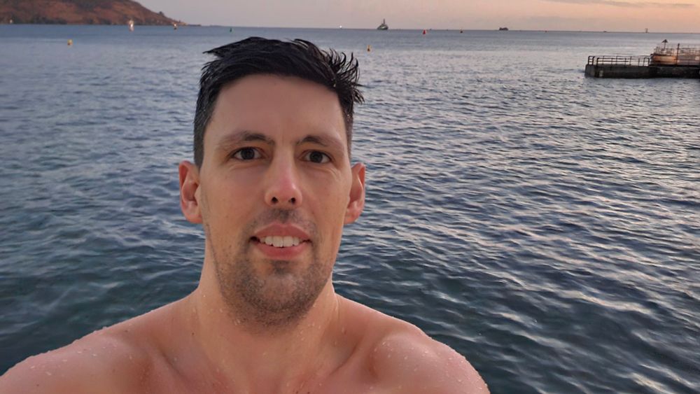 Me looking at the camera with the sea behind me. It is dusk as the light is low