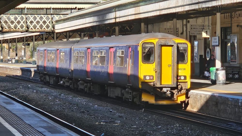 150238 sits at Exeter St Davids wearing FIrst Great Western blue livery with pink doors