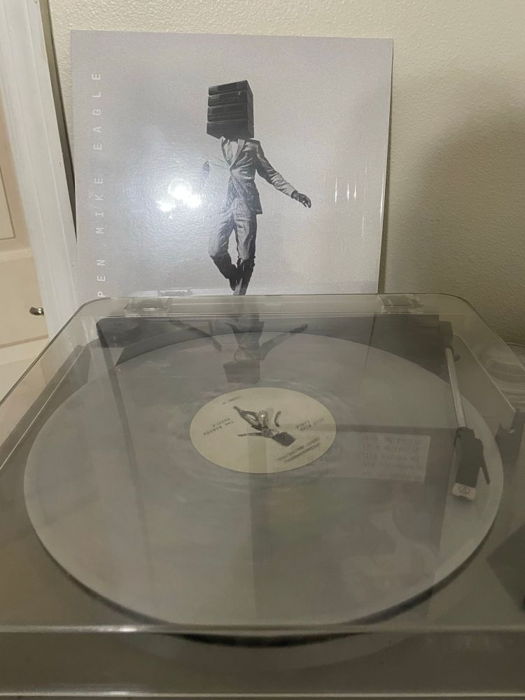 Picture of turntable playing new record from Open Mike Eagle called “Neighborhood Gods Unlimited” with the album cover sitting behind it. You can also see into my bathroom a bit.