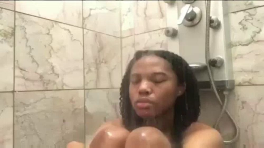 a woman is taking a shower in a bathroom with a shower head .