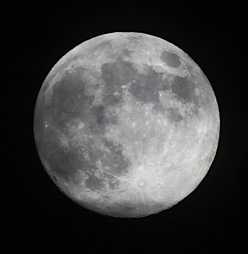 The Moon nearly Full on a dark background. 