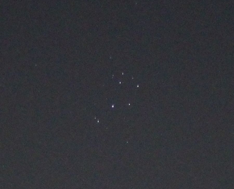 The dots of the Pleiades star cluster at centre. 