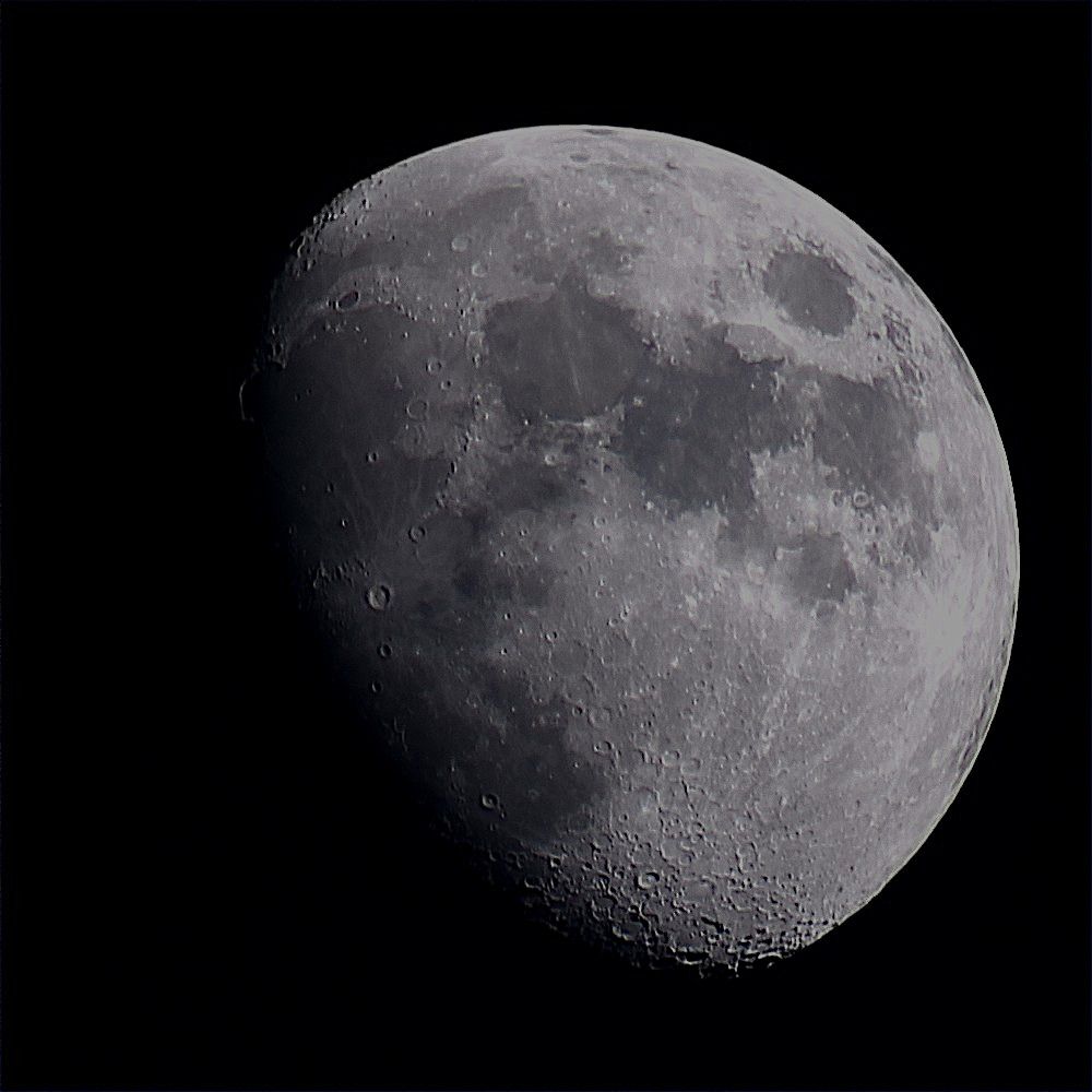 The Moon at waxing gibbous phase on a dark background. 