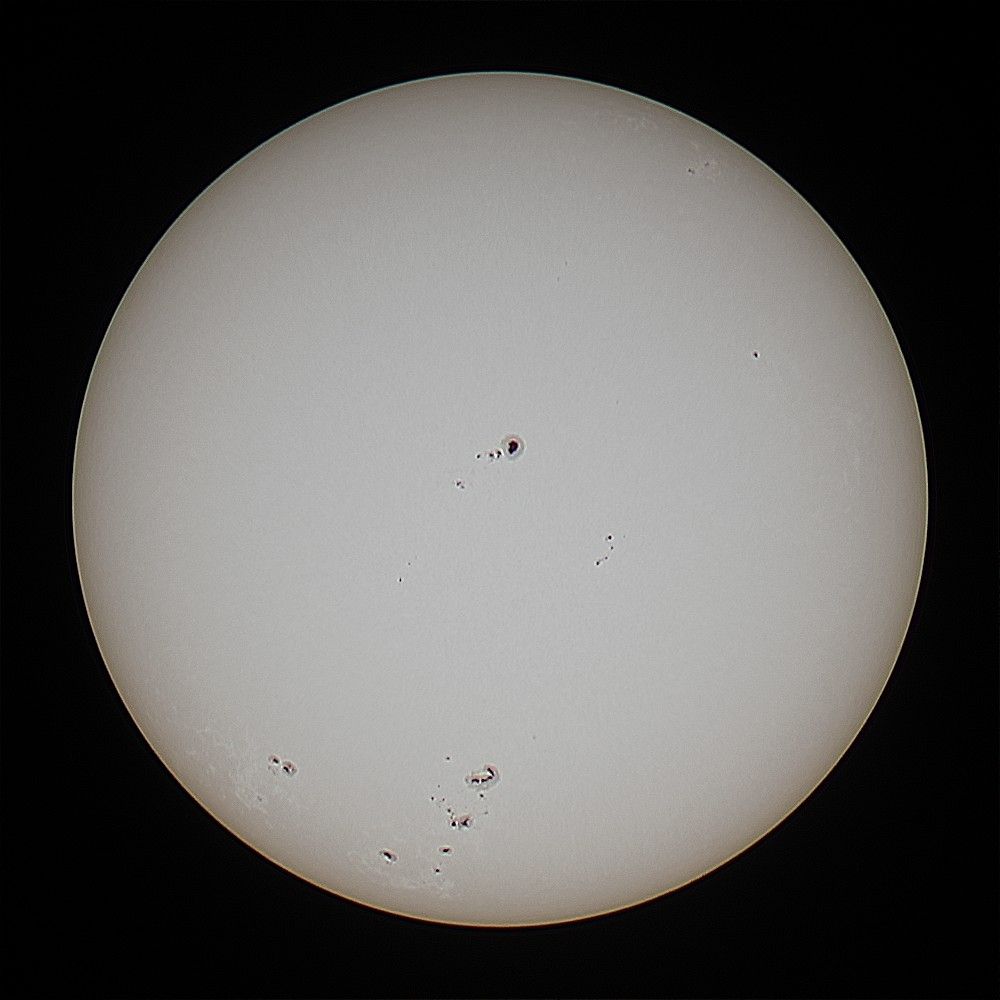 The sun and spots in white light on a dark background. 