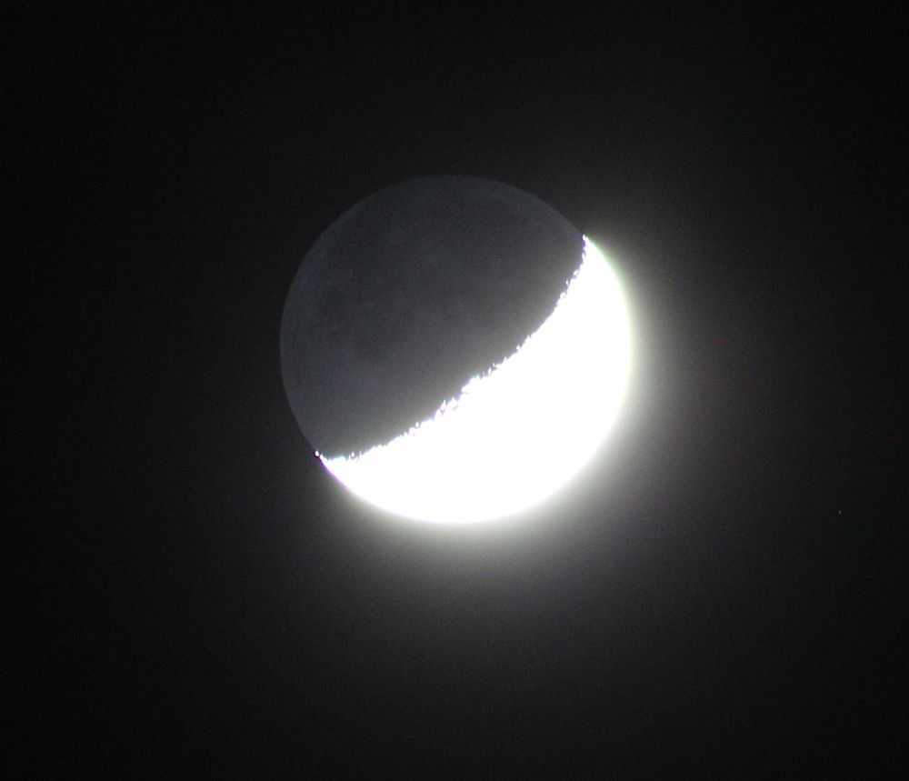 The Moon with light reflected from the Earth, on a dark background.