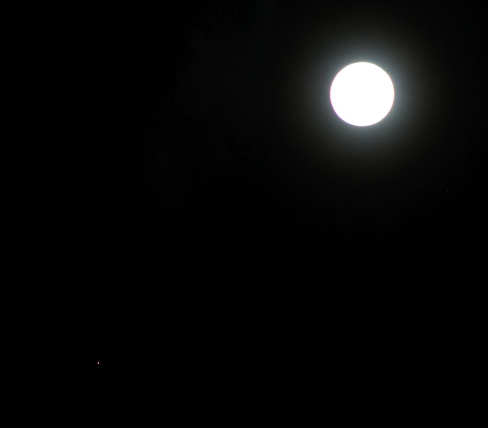 Red planet Mars dot at lower left corner. The Moon nearly full at upper right corner. Both on a dark background. 