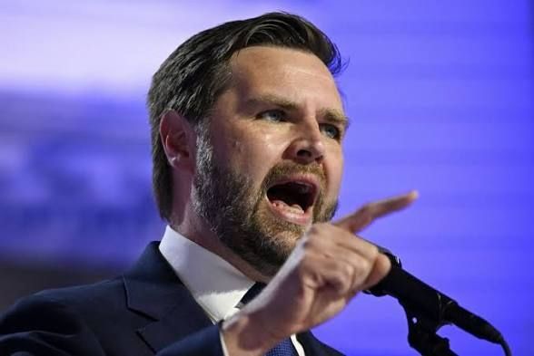 JD Vance pointing and yelling into a microphone 