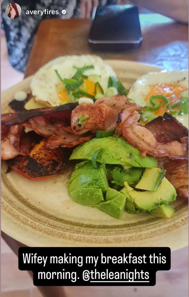 A plate of bacon, avocado, cheese and eggs with spring onion