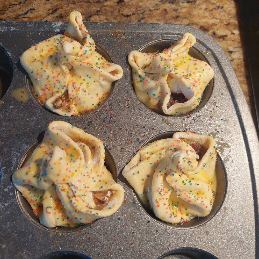 Puff pastry filled with pecan pie filling, wrapped and twisted at the top and covered in decorative sugar.