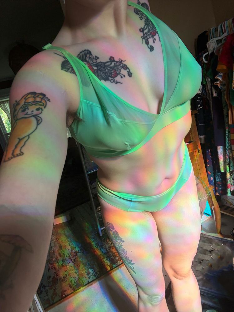 A matching sea green bra and panty on a body with refracting rainbows