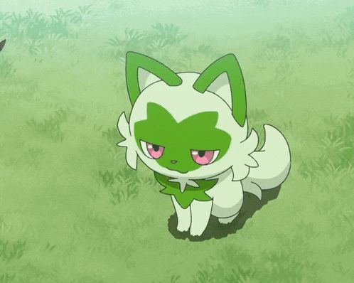 a green and white cat with its eyes closed laying in the grass